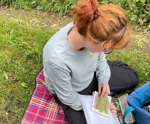 woman sitting on ground painting