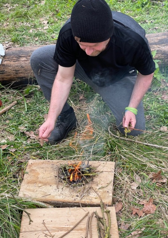 man lighting small fire