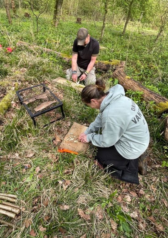 two people whittling wood